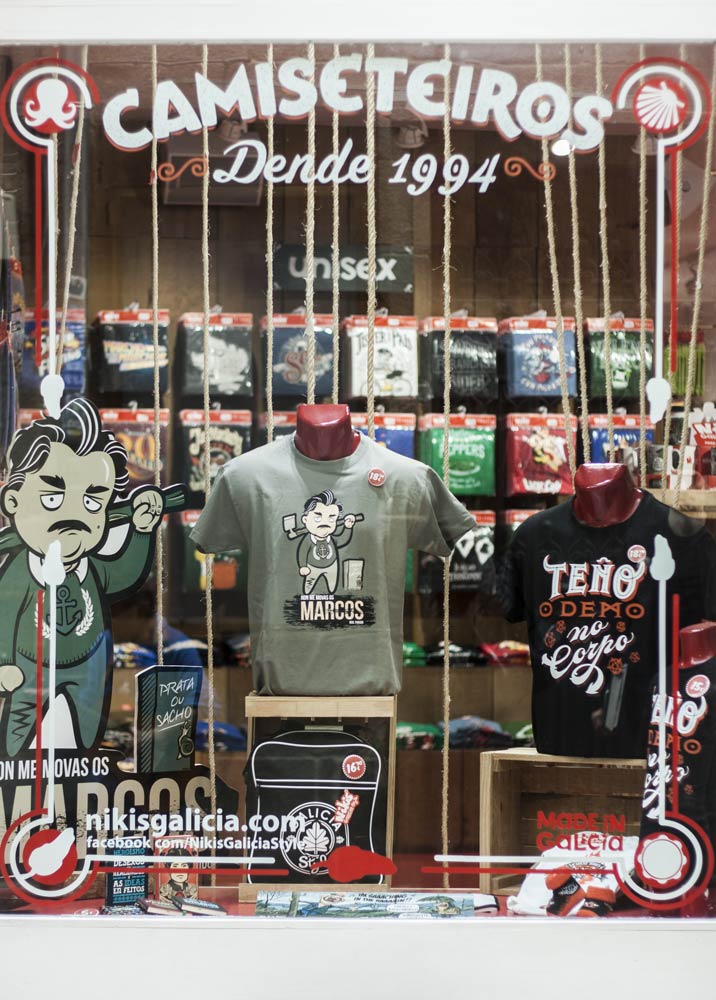 Camiseta y display promocional de Marcos, prata ou Sacho, en escaparate de Nikis Galicia. Bizarrografico.